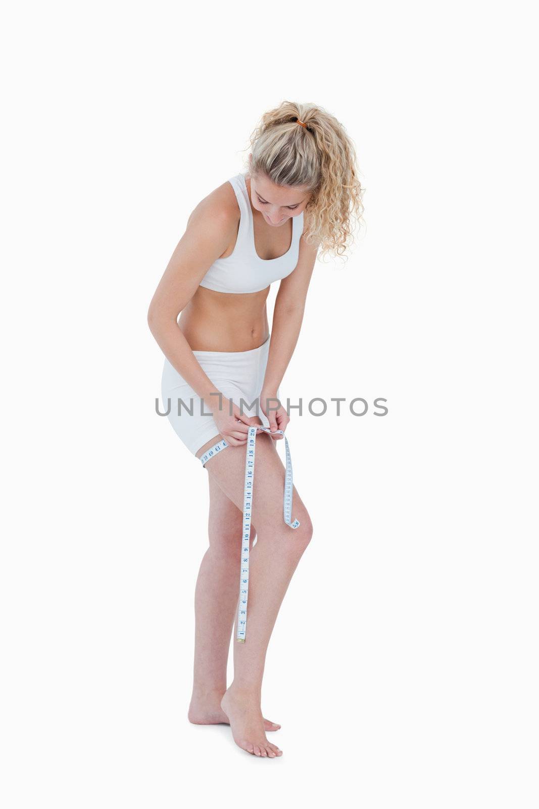 Young blonde woman measuring her thigh in underwear by Wavebreakmedia