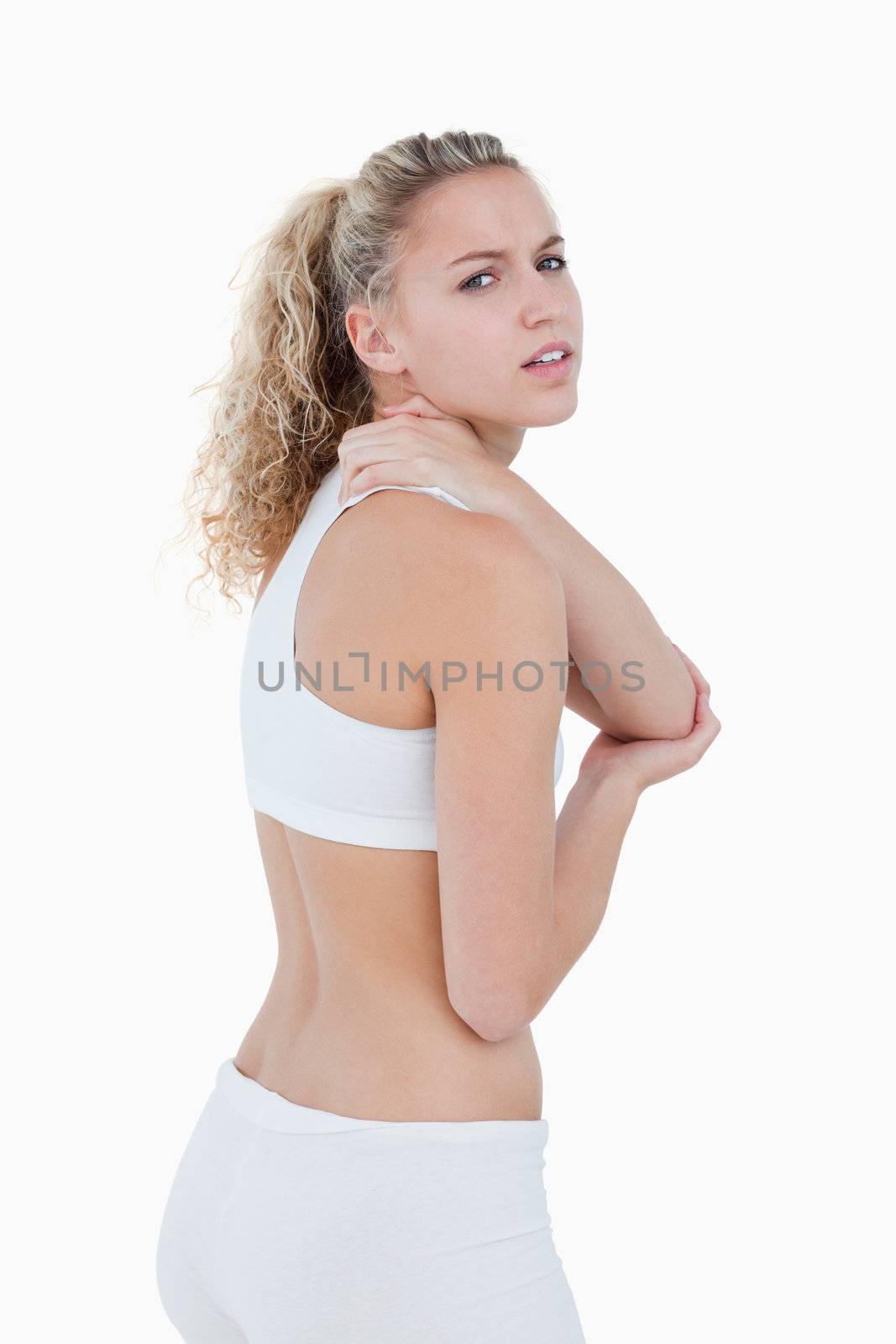 Young woman showing a pain in her shoulder against a white background