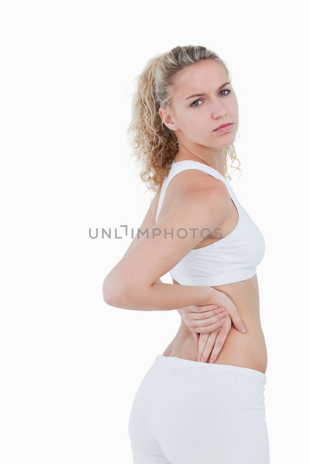 Young serious woman showing a pain in the back by Wavebreakmedia