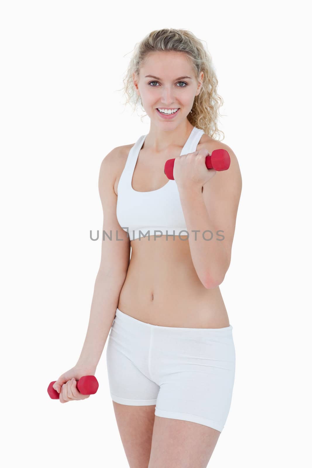 Young woman looking at the camera while lifting weights against a white background