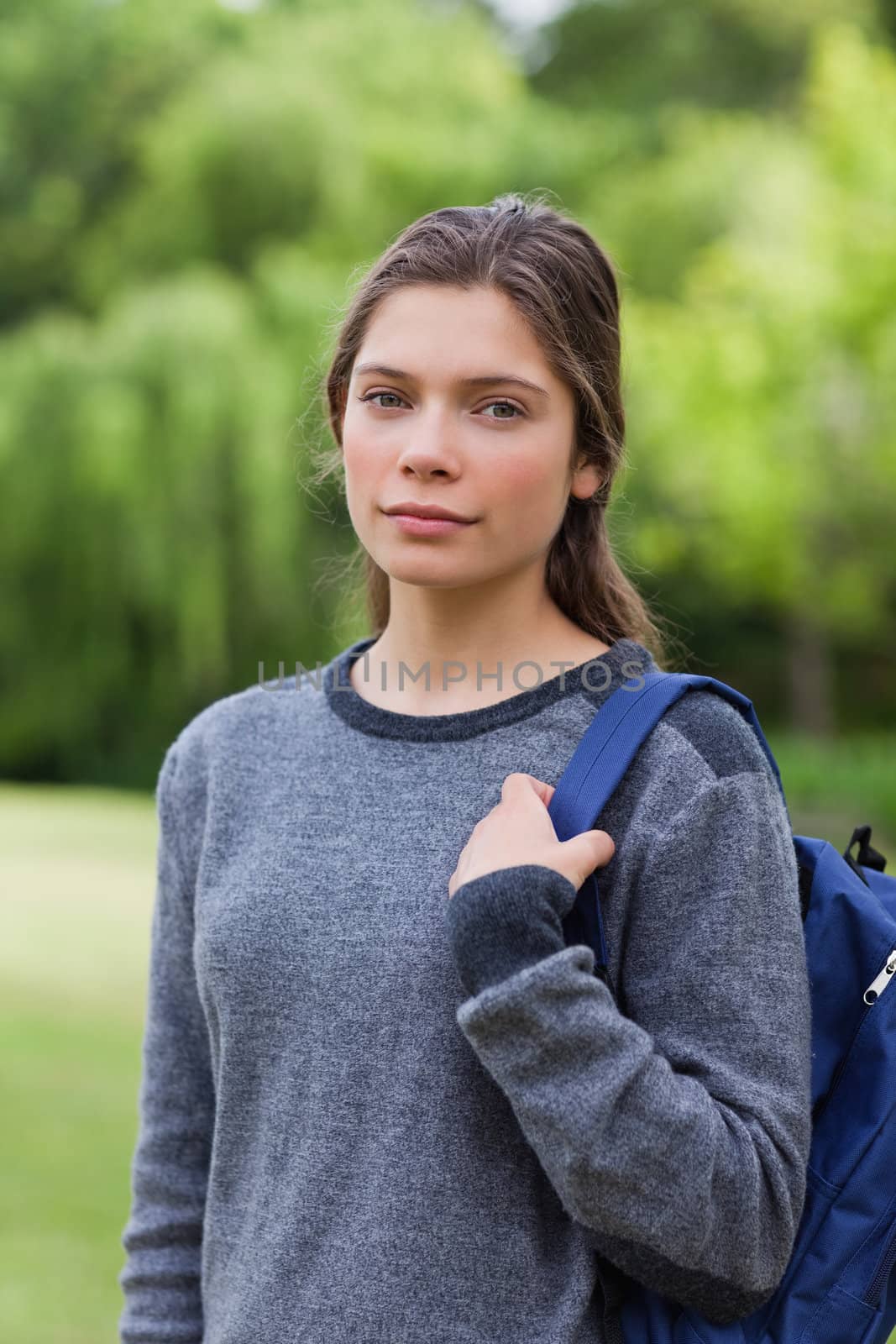 Young girl looking straight at the camera while standing upright in the countryside