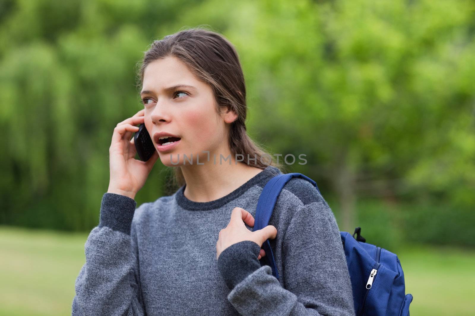 Young calm girl talking on the phone while looking towards the s by Wavebreakmedia