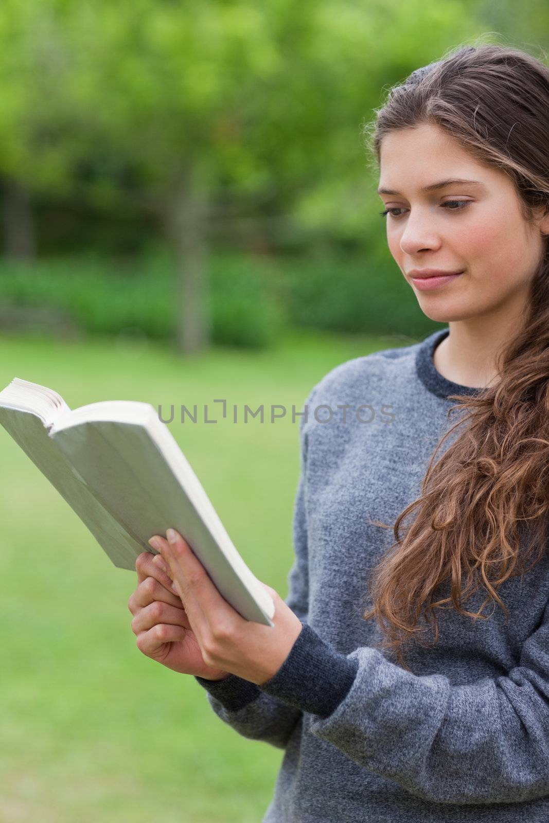 Young relaxed girl reading a book in a park by Wavebreakmedia