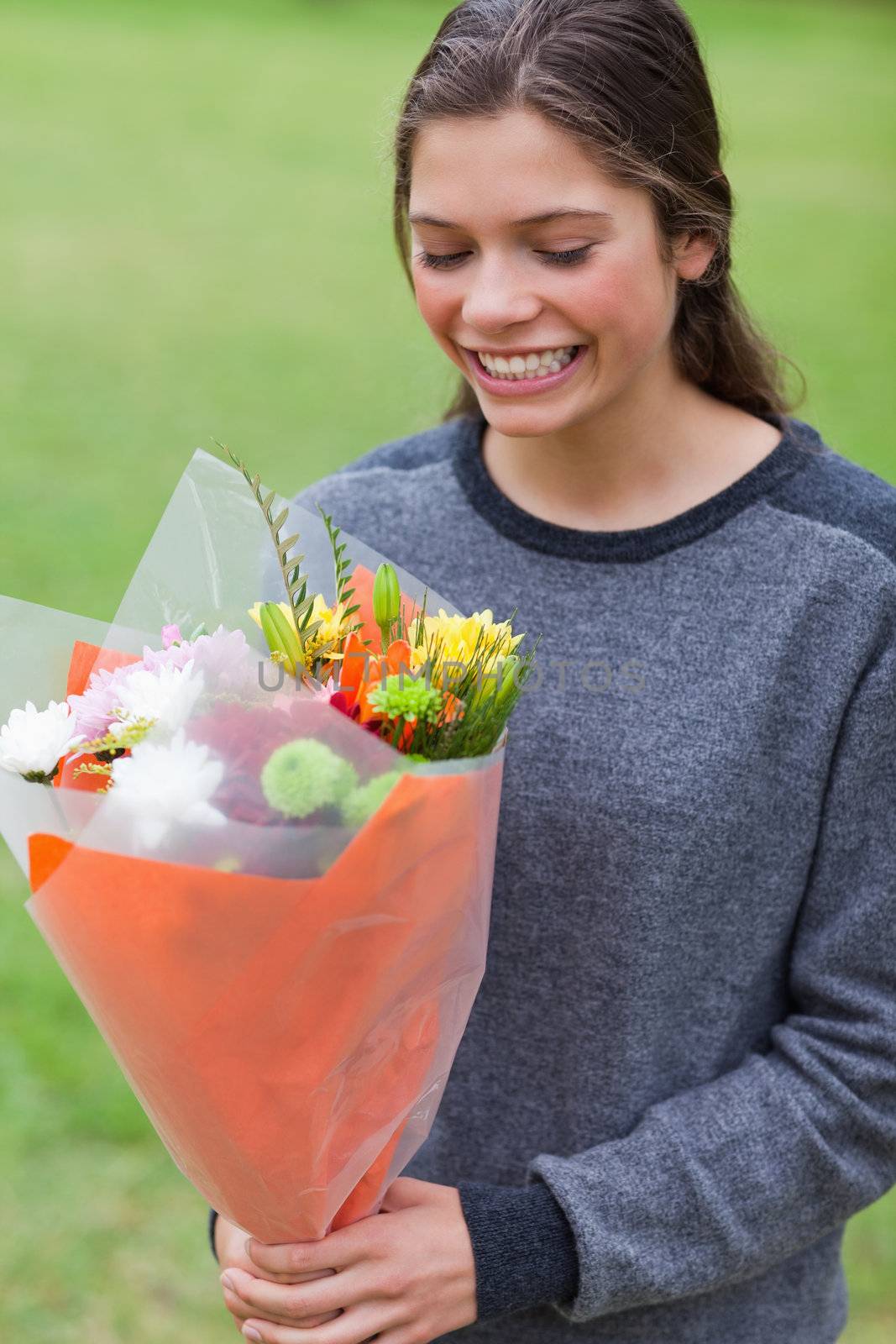Smiling teenage receiving a bunch of flowers by Wavebreakmedia