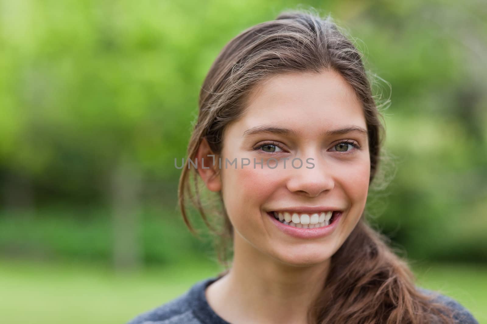 Young woman looking at the camera while showing a beaming smile