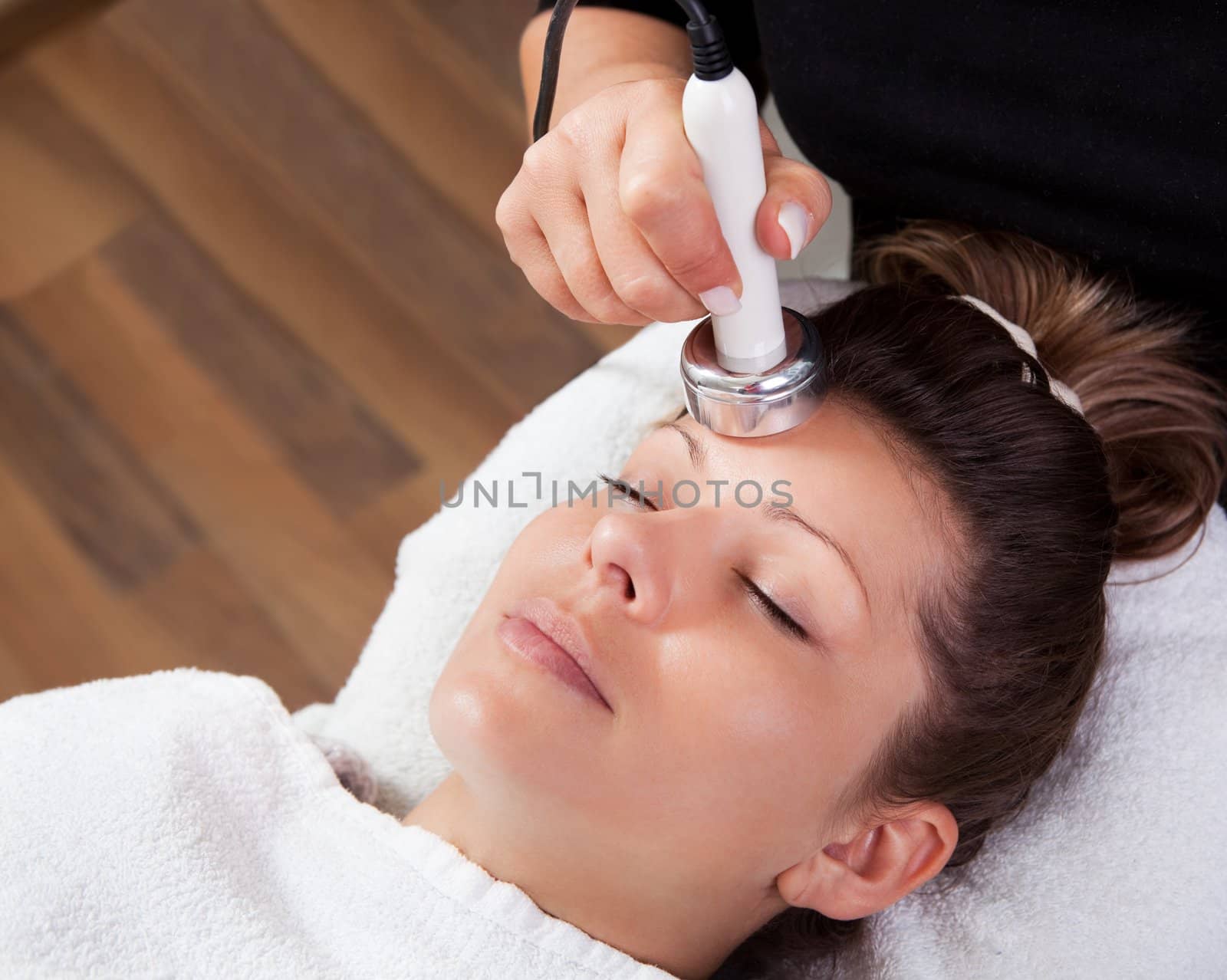 Young woman receiving laser therapy. Spa studio shot