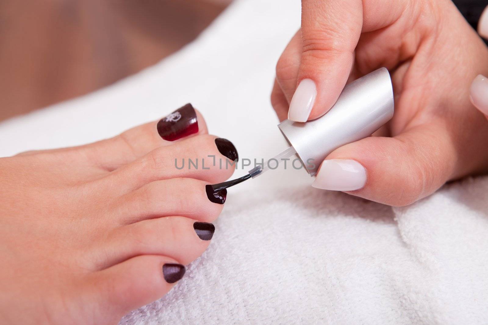 Beautician working on toenails. Spa studio shot