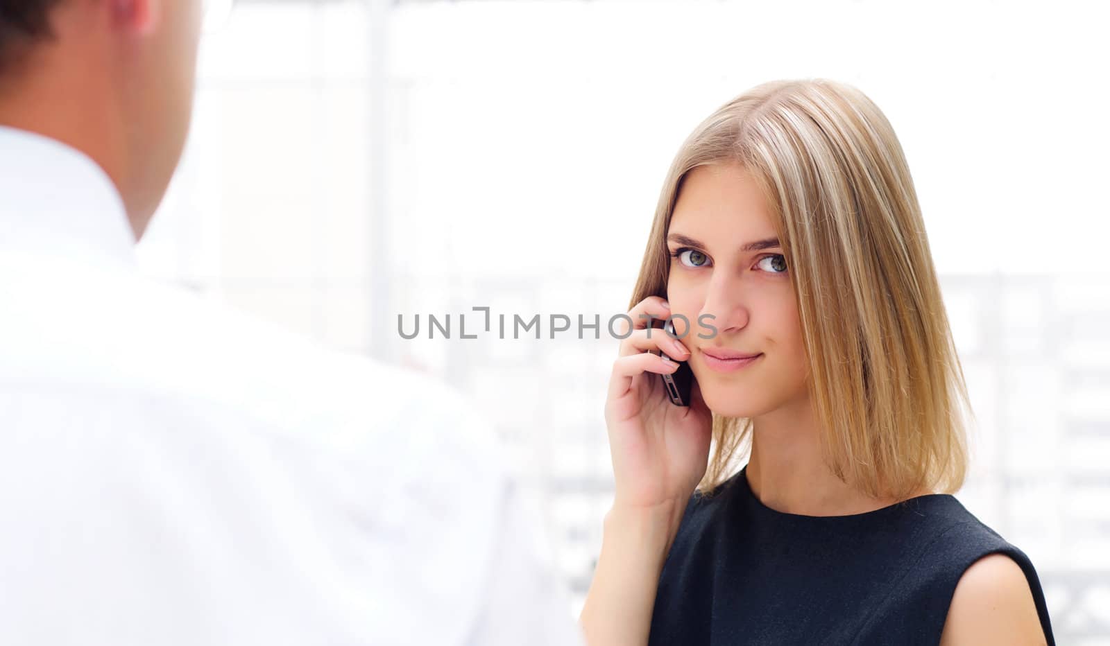 business male and business female discuss reports, Woman talking on cell phone