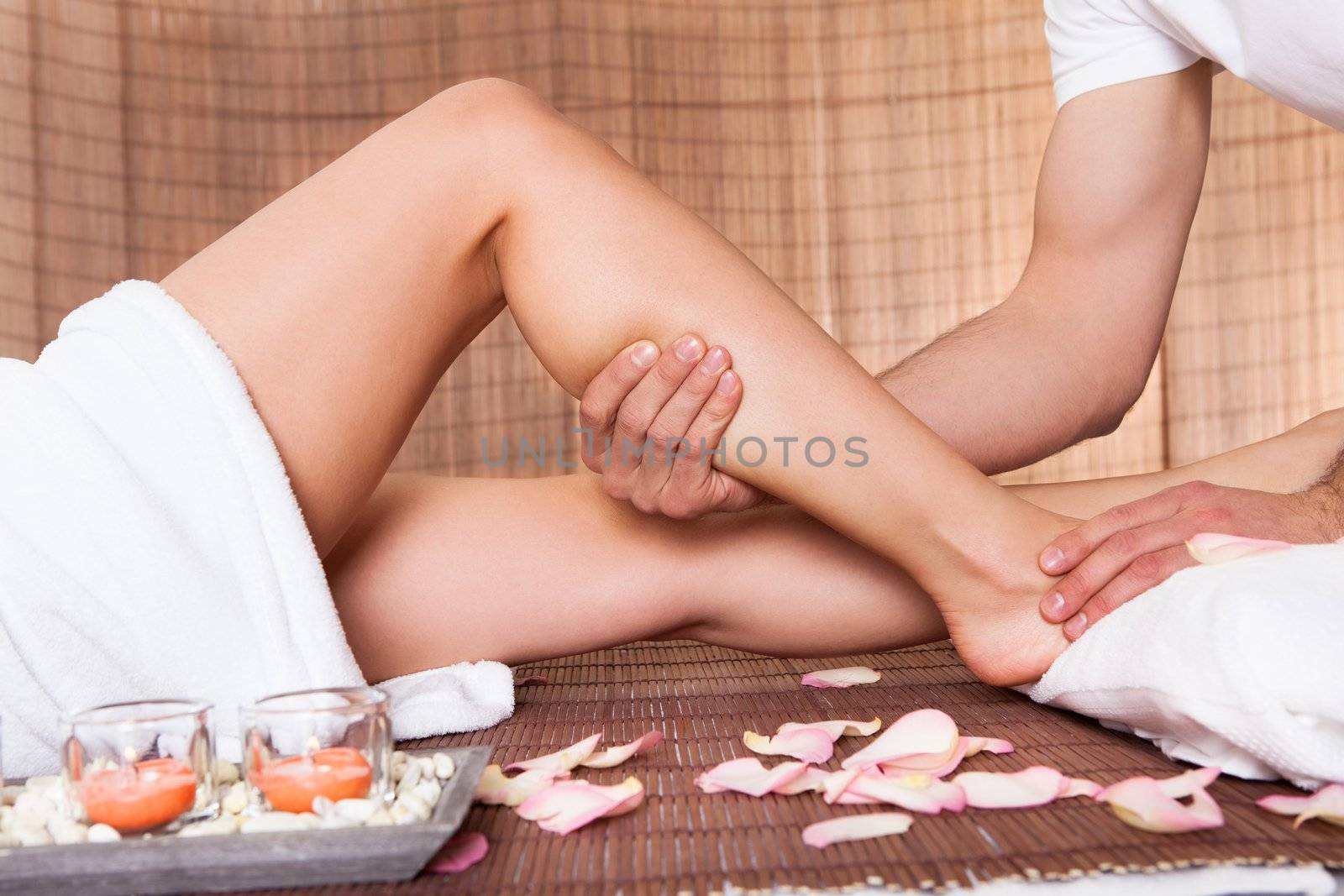 Beautiful young woman getting feet massage treatment at spa