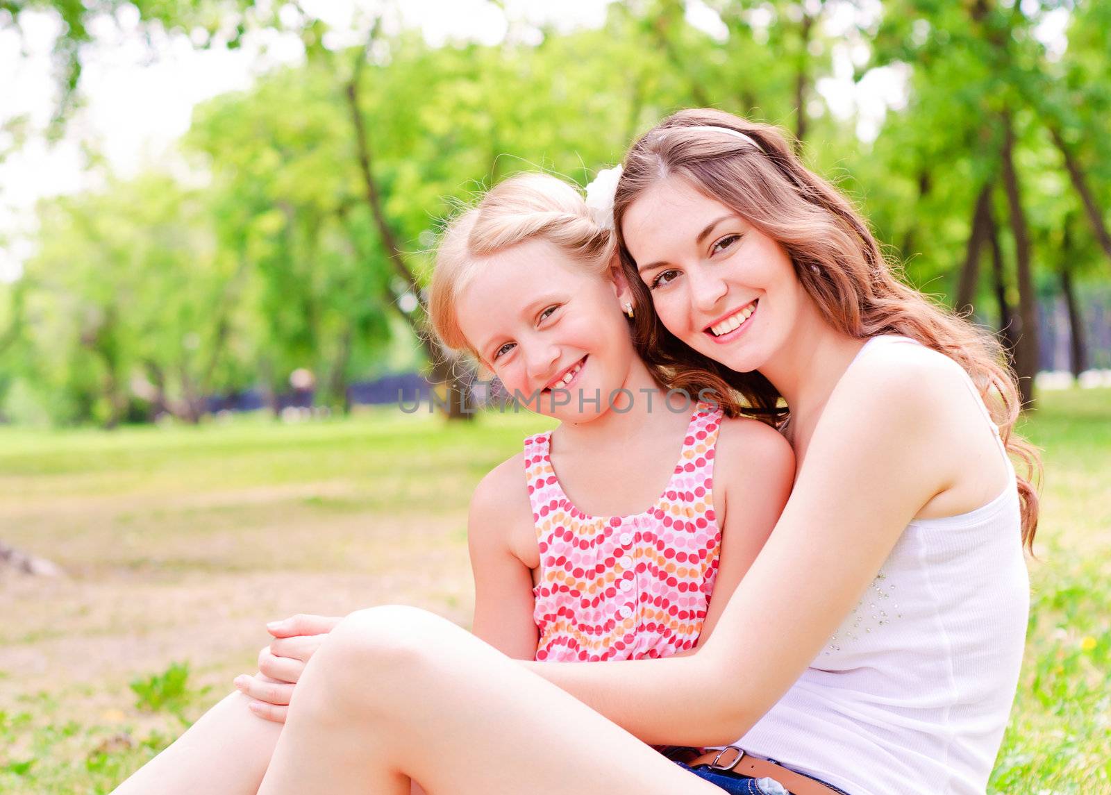 mother and daughter sitting together on the grass, and spend time with family