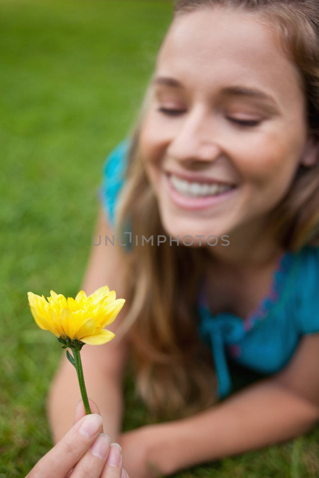 Beautiful yellow flower held by a smiling young woman