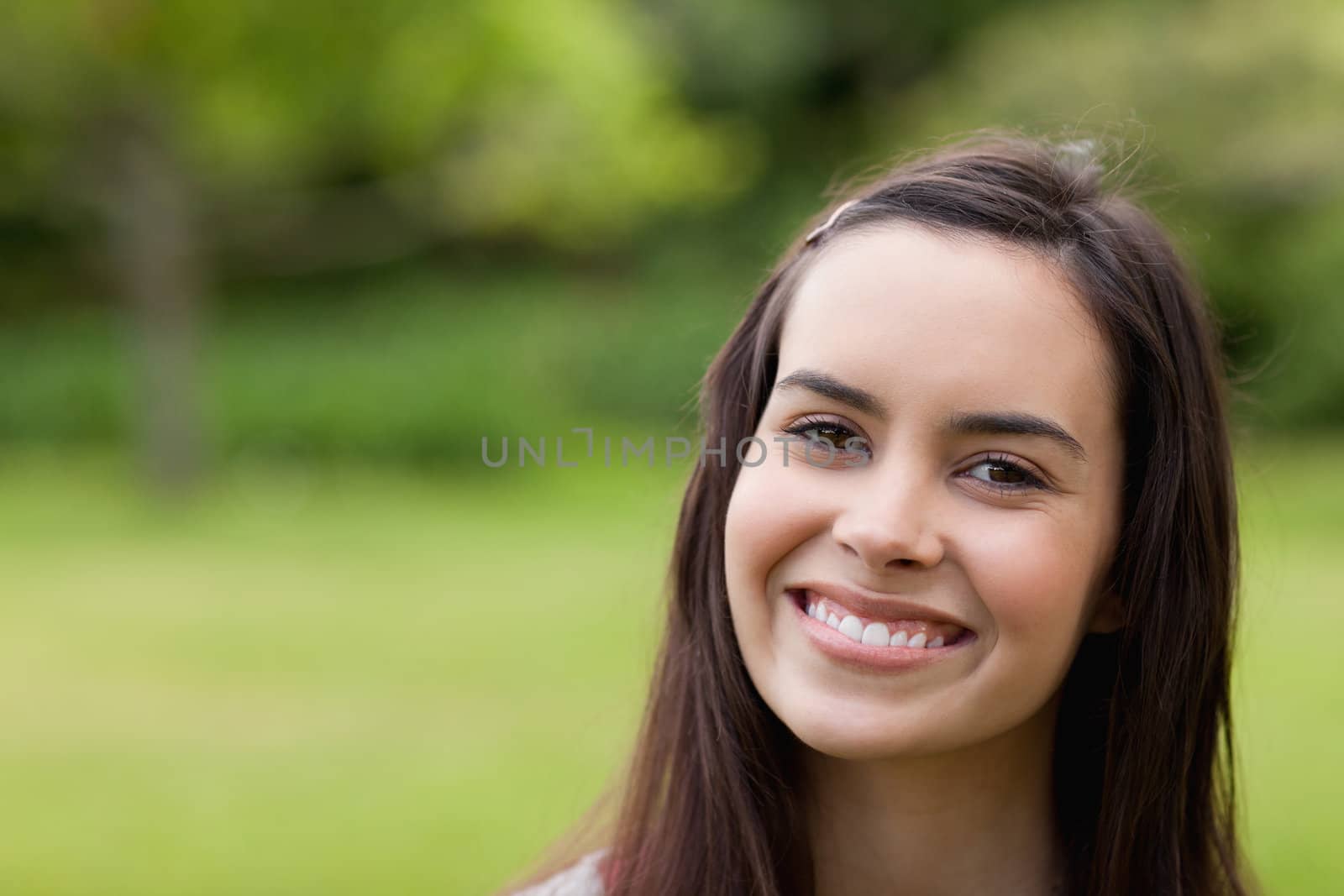 Young smiling woman looking at the camera while standing up in a by Wavebreakmedia