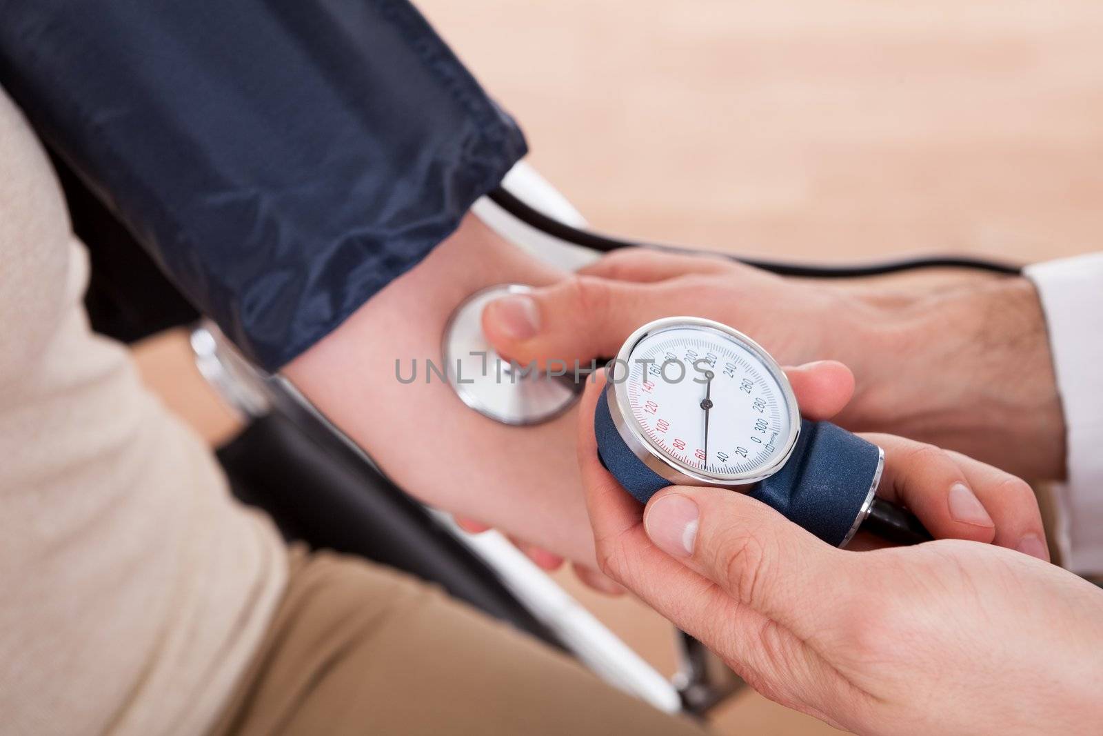 Doctor checking blood pressure by AndreyPopov