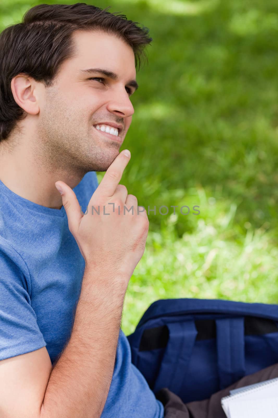 Young smiling man placing his finger on his chin by Wavebreakmedia