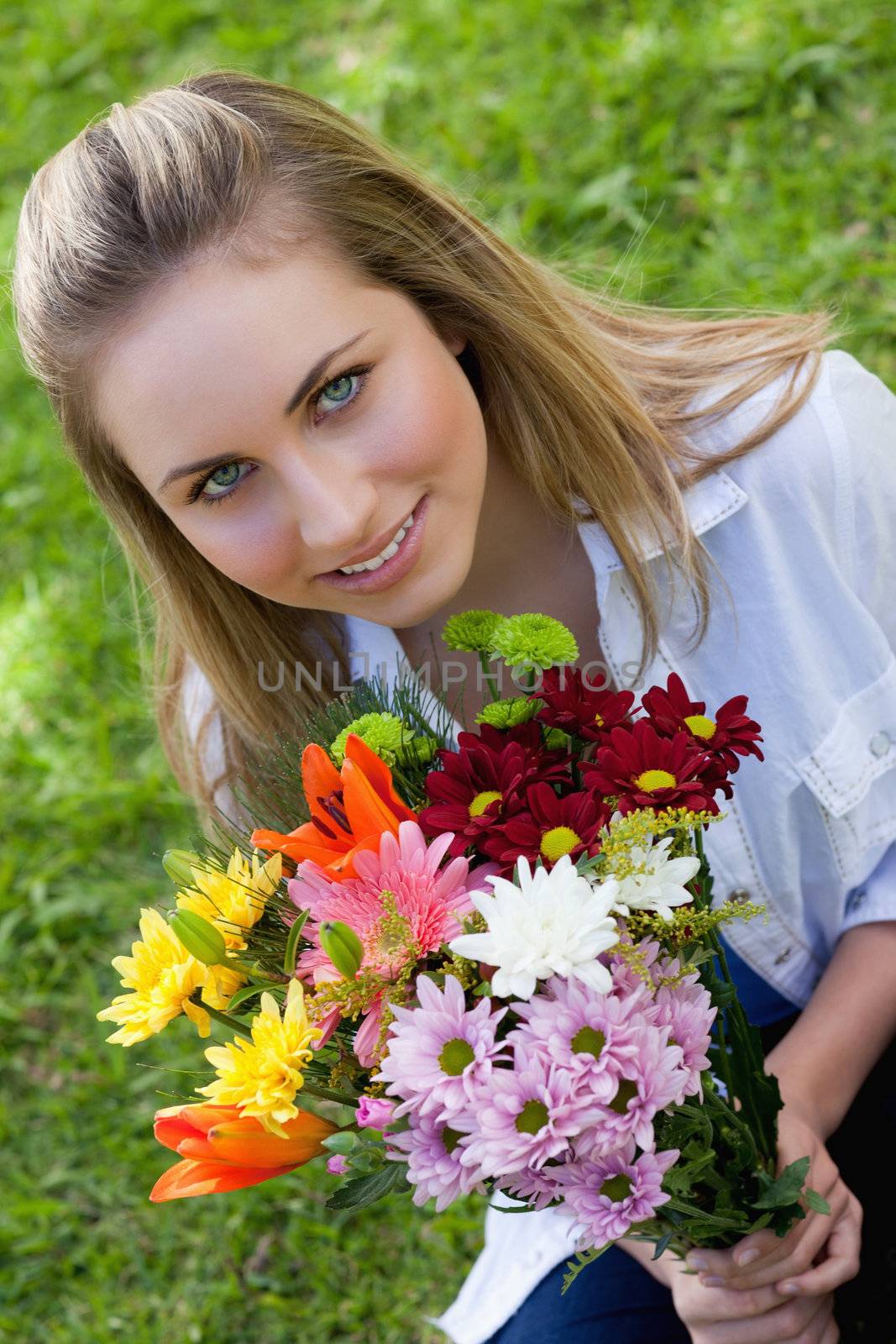 Attractive blonde teenager holding a beautiful bunch of flower by Wavebreakmedia