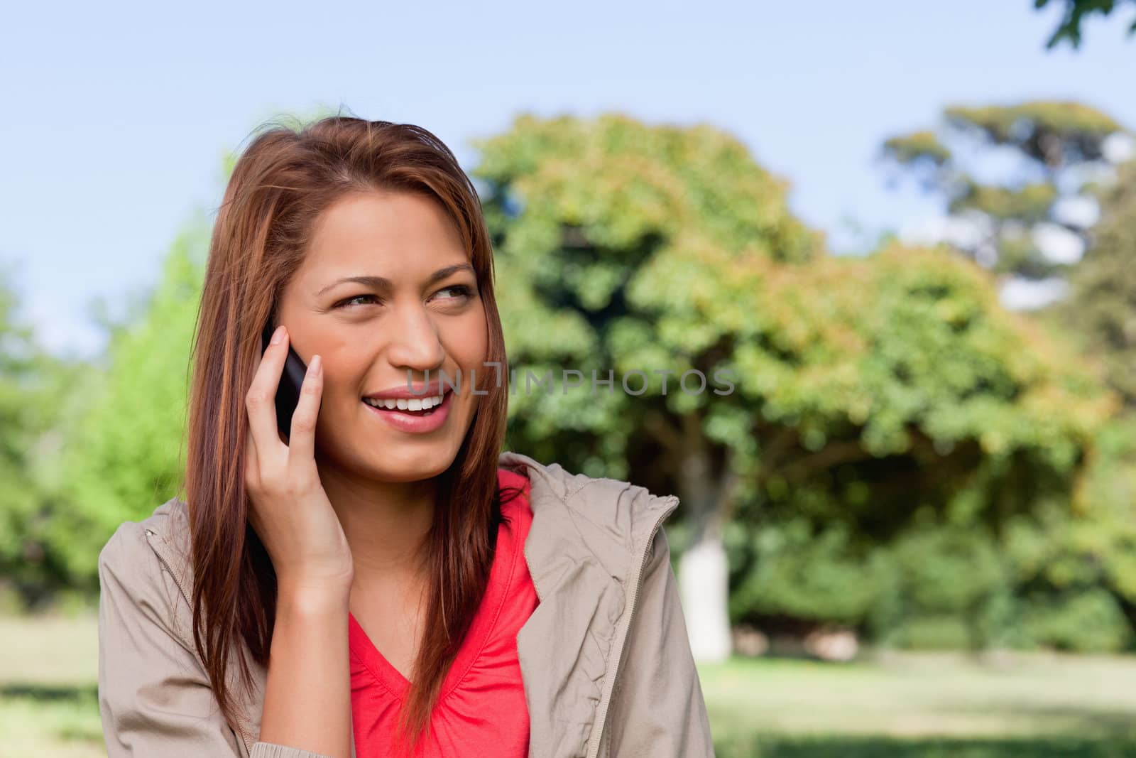 Woman smiling while looking towards her left side in an open gra by Wavebreakmedia