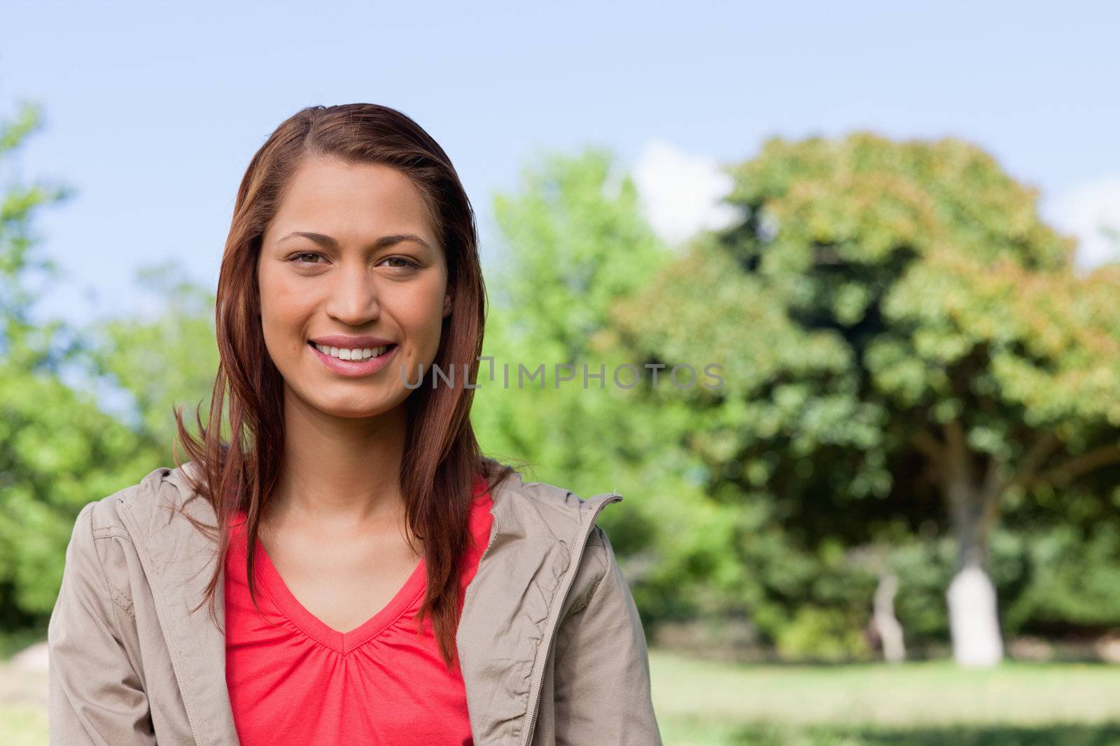 Young woman looking straight ahead with a smile on her face by Wavebreakmedia