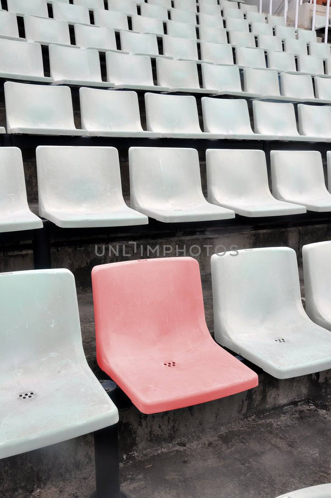 A single red chair in a multitude of white chair
