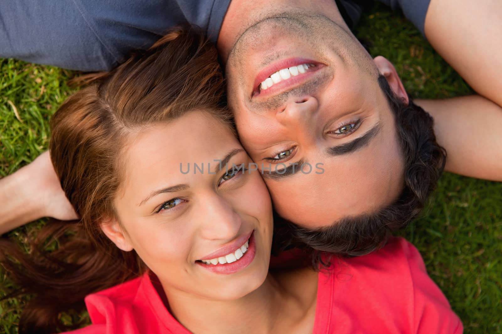 Close-up of two friends looking upwards while lying head to shou by Wavebreakmedia