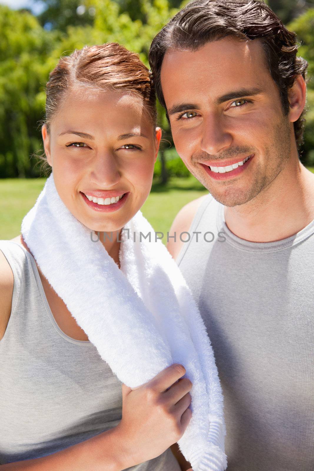 Woman holding a towel around her neck smiling with a man