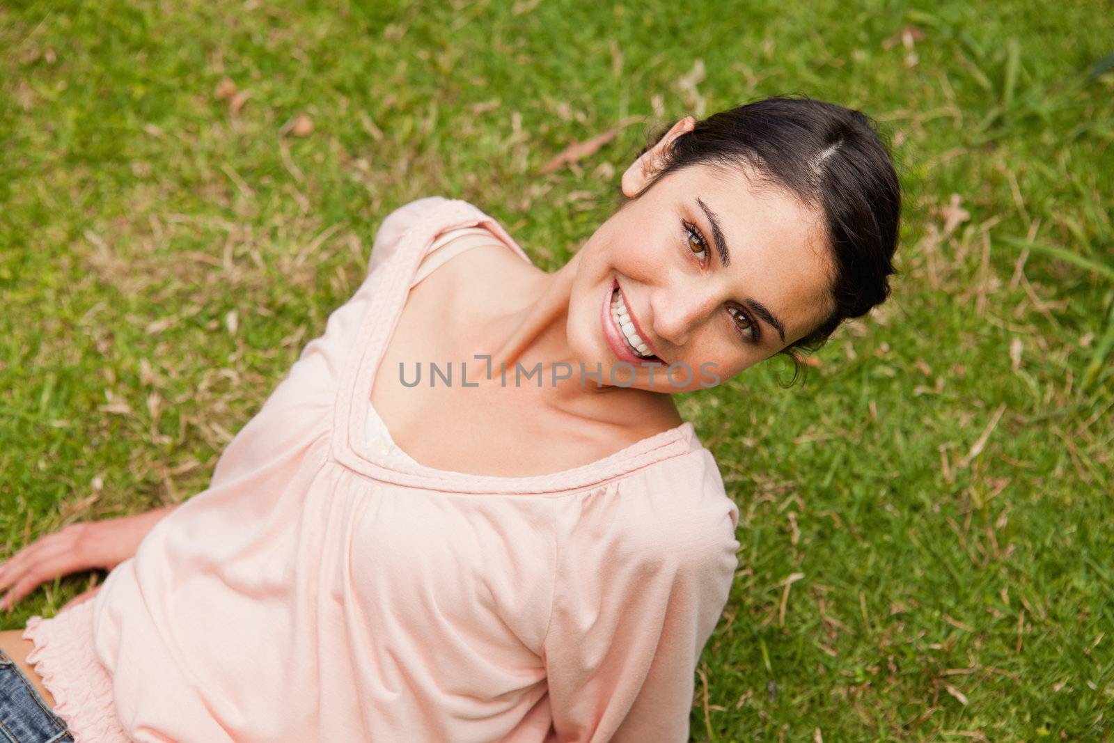 Smiling woman looking upwards while lying down by Wavebreakmedia