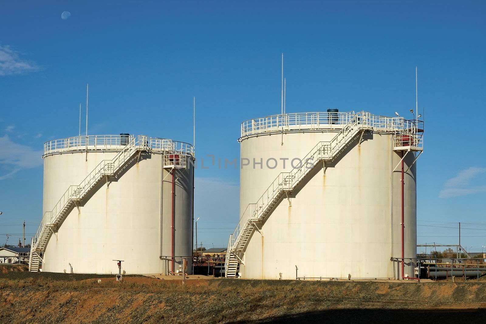 Vertical steel tanks for the storage of oil on a background of blue sky.