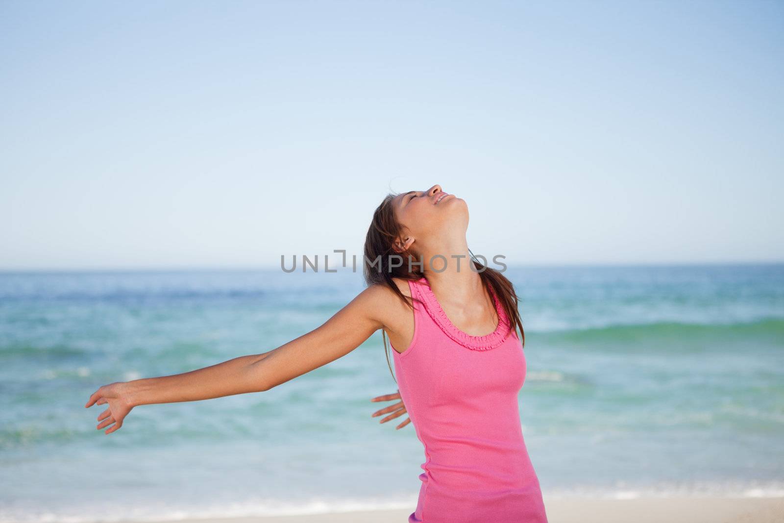 Young woman leaning her body back while sunbathing on the beach