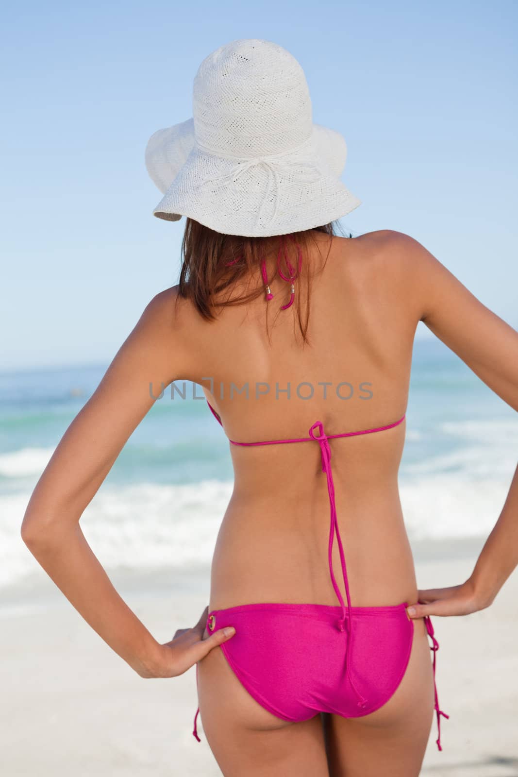 Back view of a beautiful teenager standing upright while looking by Wavebreakmedia