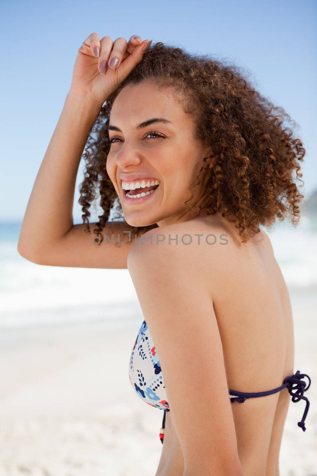 Smiling woman placing her hand on her forehead while standing on by Wavebreakmedia