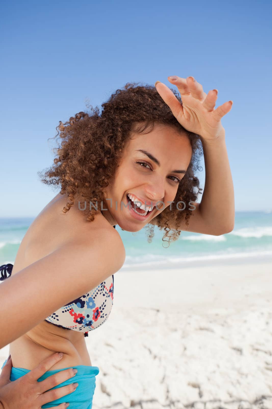 Young smiling woman placing her hand on her forehead to look at  by Wavebreakmedia
