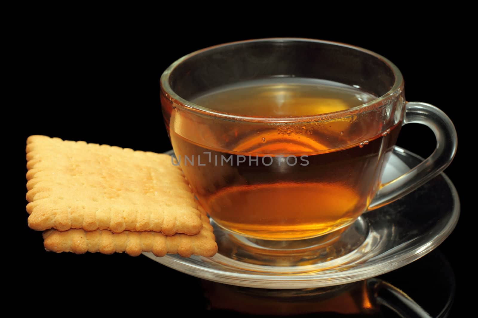 Cup of tea with biscuits on black background