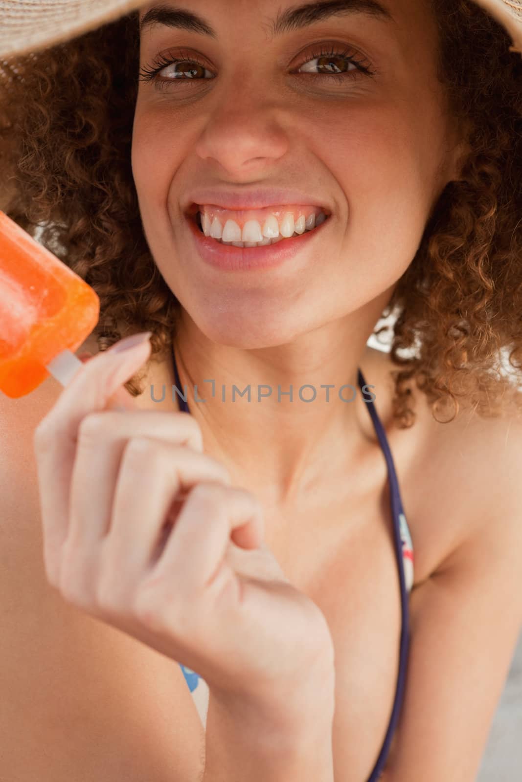 Young woman showing a great smile while holding a popsicle by Wavebreakmedia