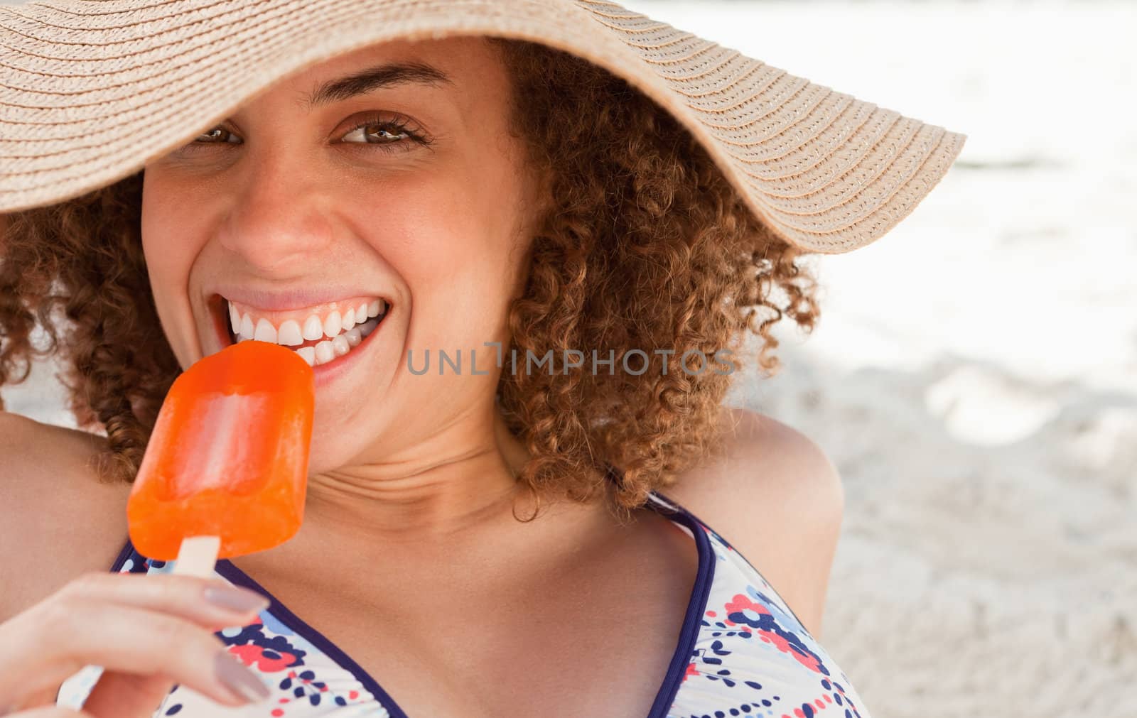 Young woman looking at the camera while eating a delicious ice cream by Wavebreakmedia