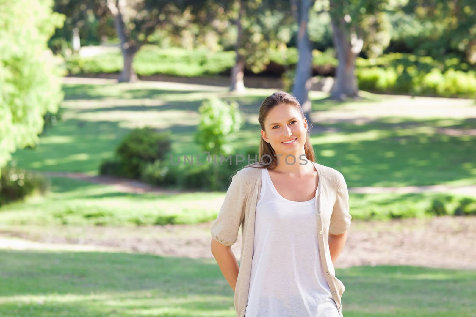 Smiling woman standing in the park by Wavebreakmedia