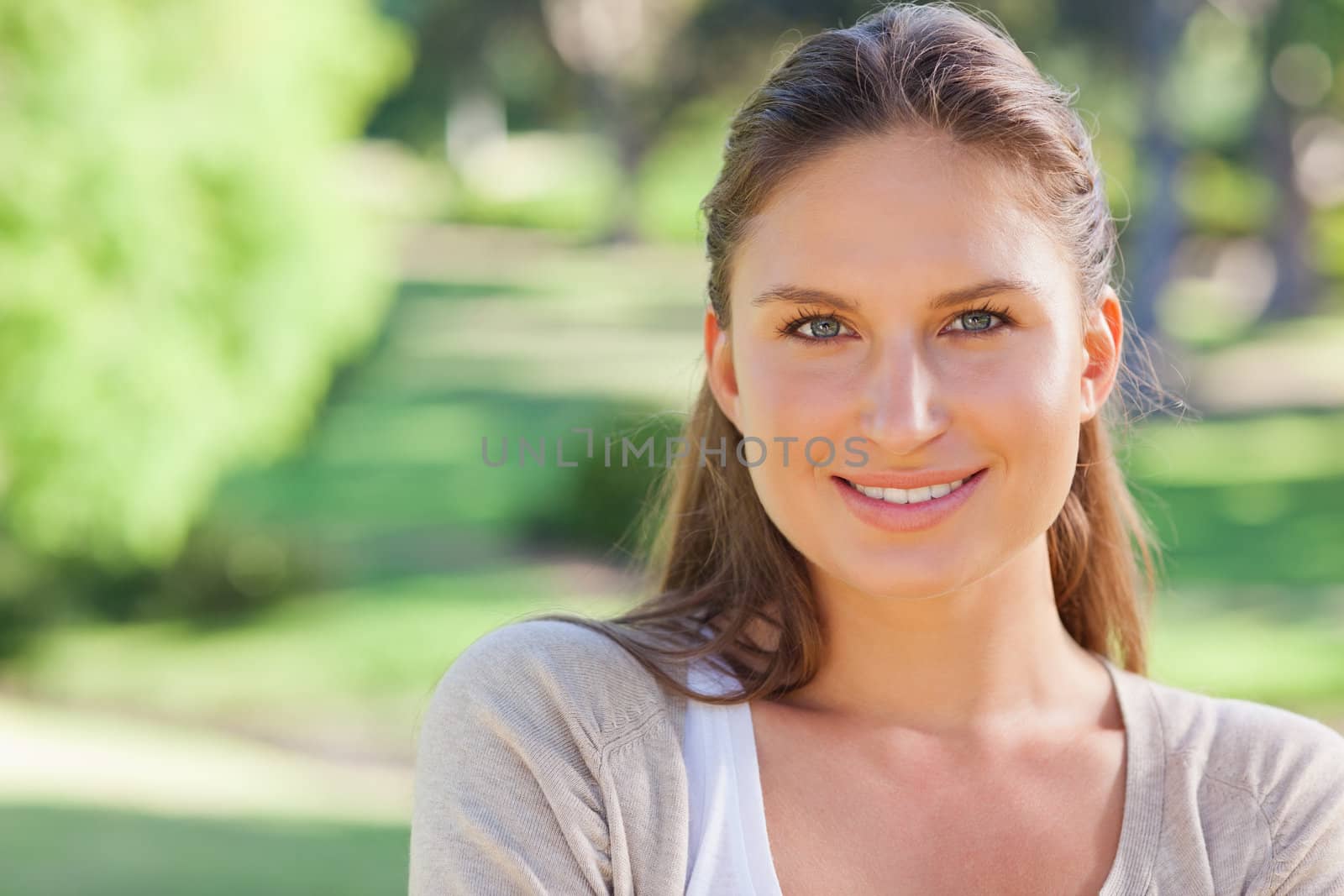 Cheerful smiling young woman in the park