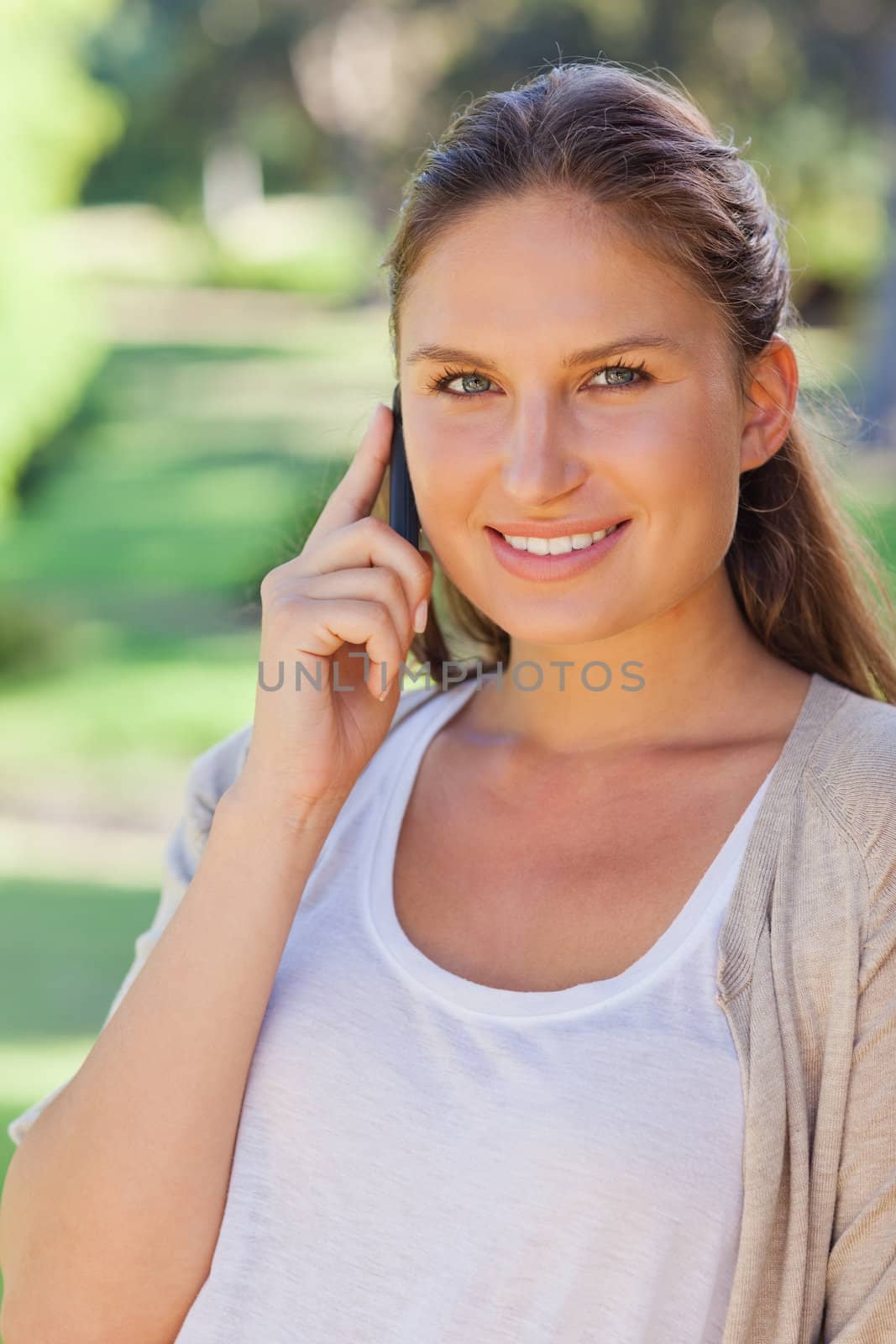 Close up of smiling woman on her cellphone in the park by Wavebreakmedia
