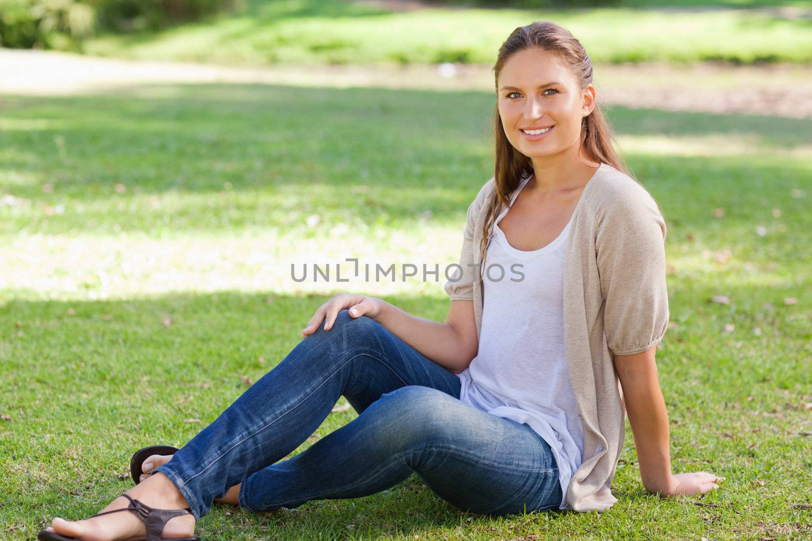 Smiling young woman sitting on the lawn