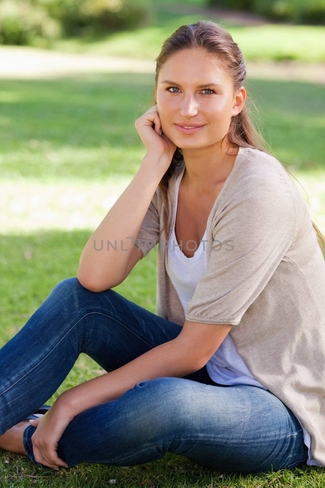 Thoughtful young woman sitting on the lawn