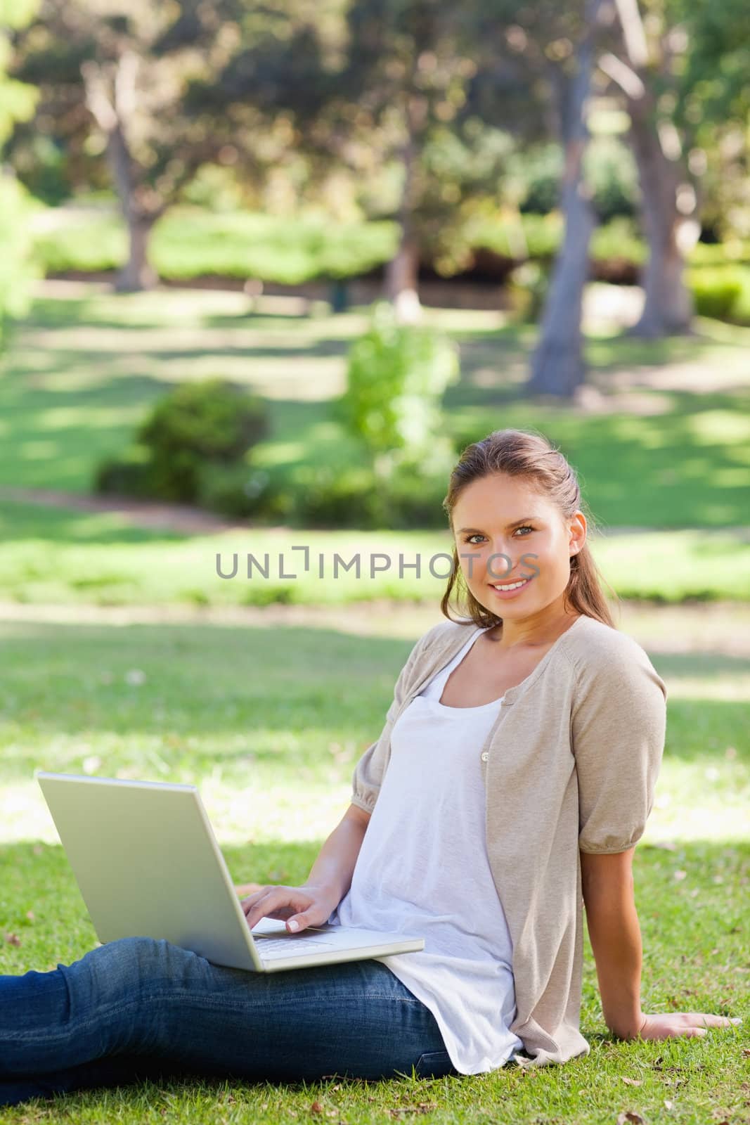 Smiling woman with her notebook in the park by Wavebreakmedia