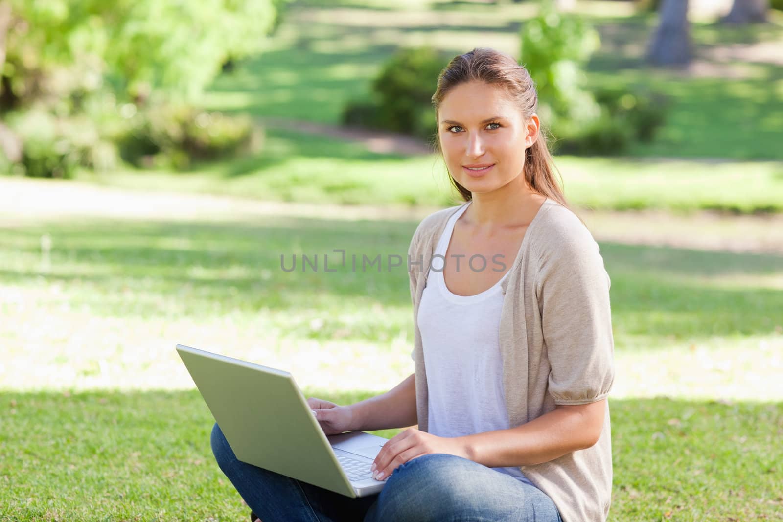 Young woman with her laptop sitting on the grass