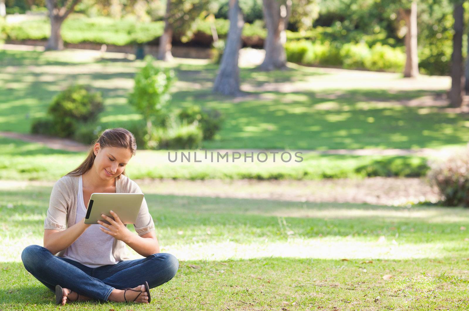 Woman in the park with a tablet computer by Wavebreakmedia