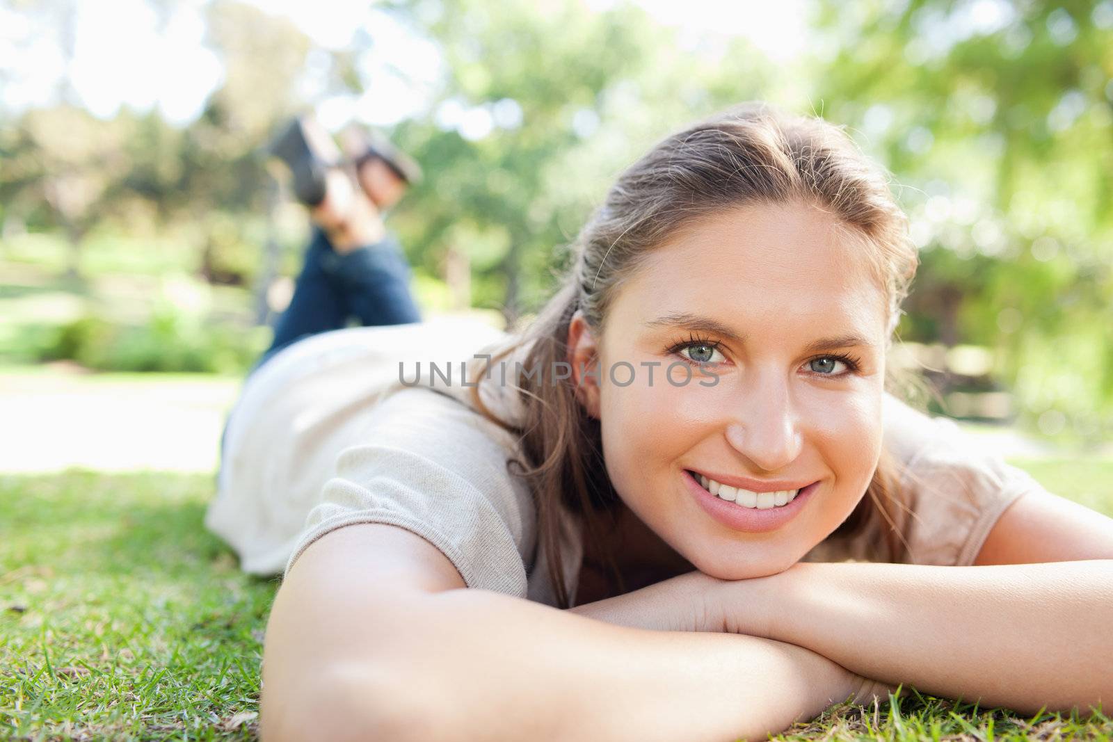 Smiling young woman lying on the lawn