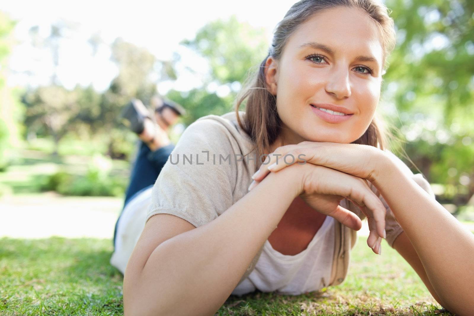 Smiling woman laying on the lawn by Wavebreakmedia