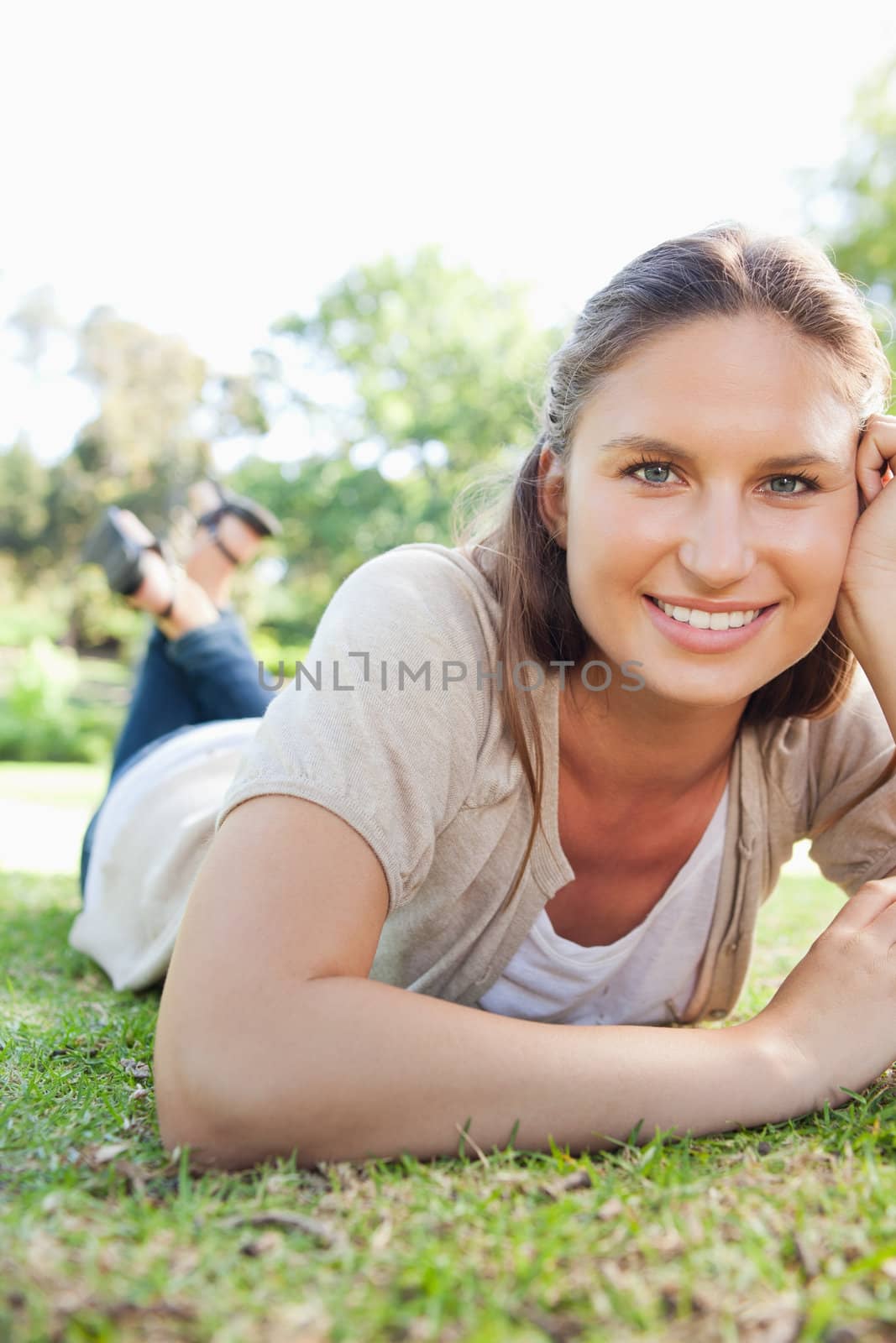 Smiling woman laying on the grass by Wavebreakmedia