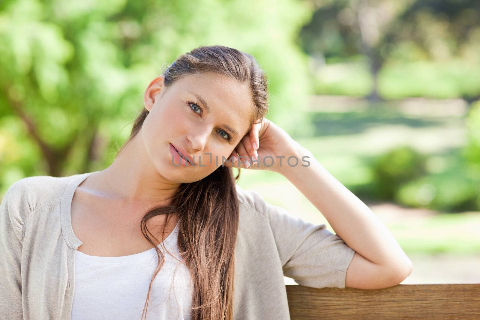 Thoughtful young woman sitting on a park bench