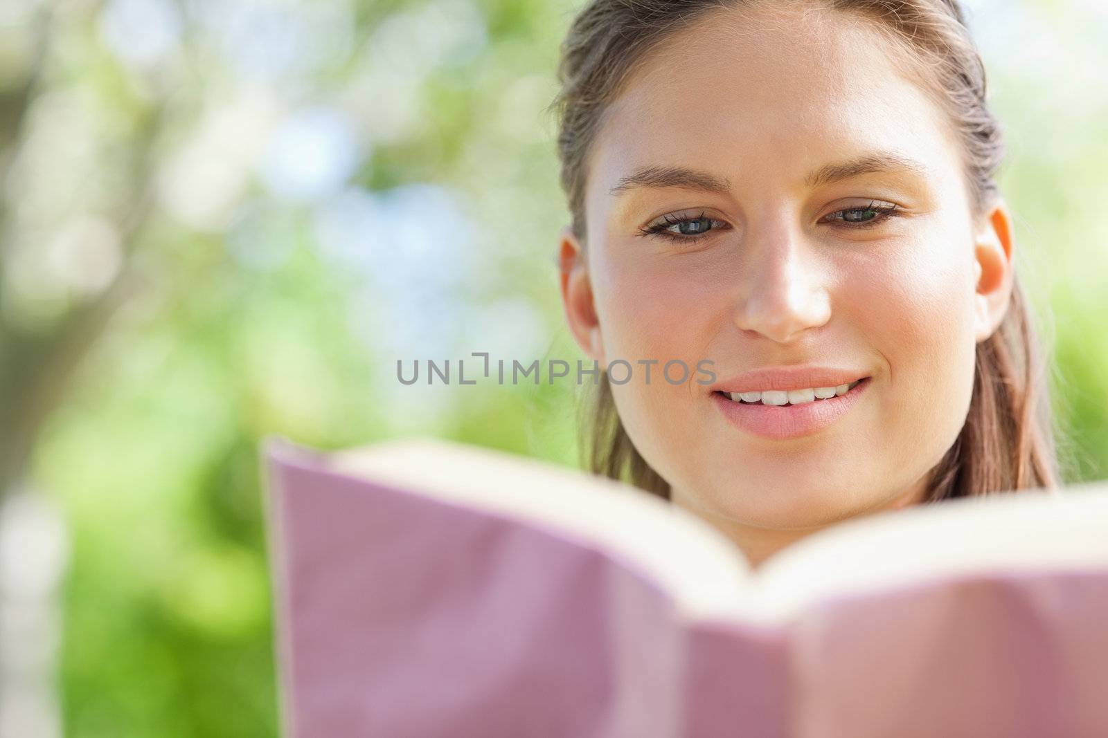 Woman reading her book in the park by Wavebreakmedia