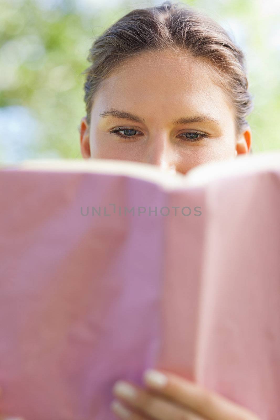 Young woman reading a book in the park