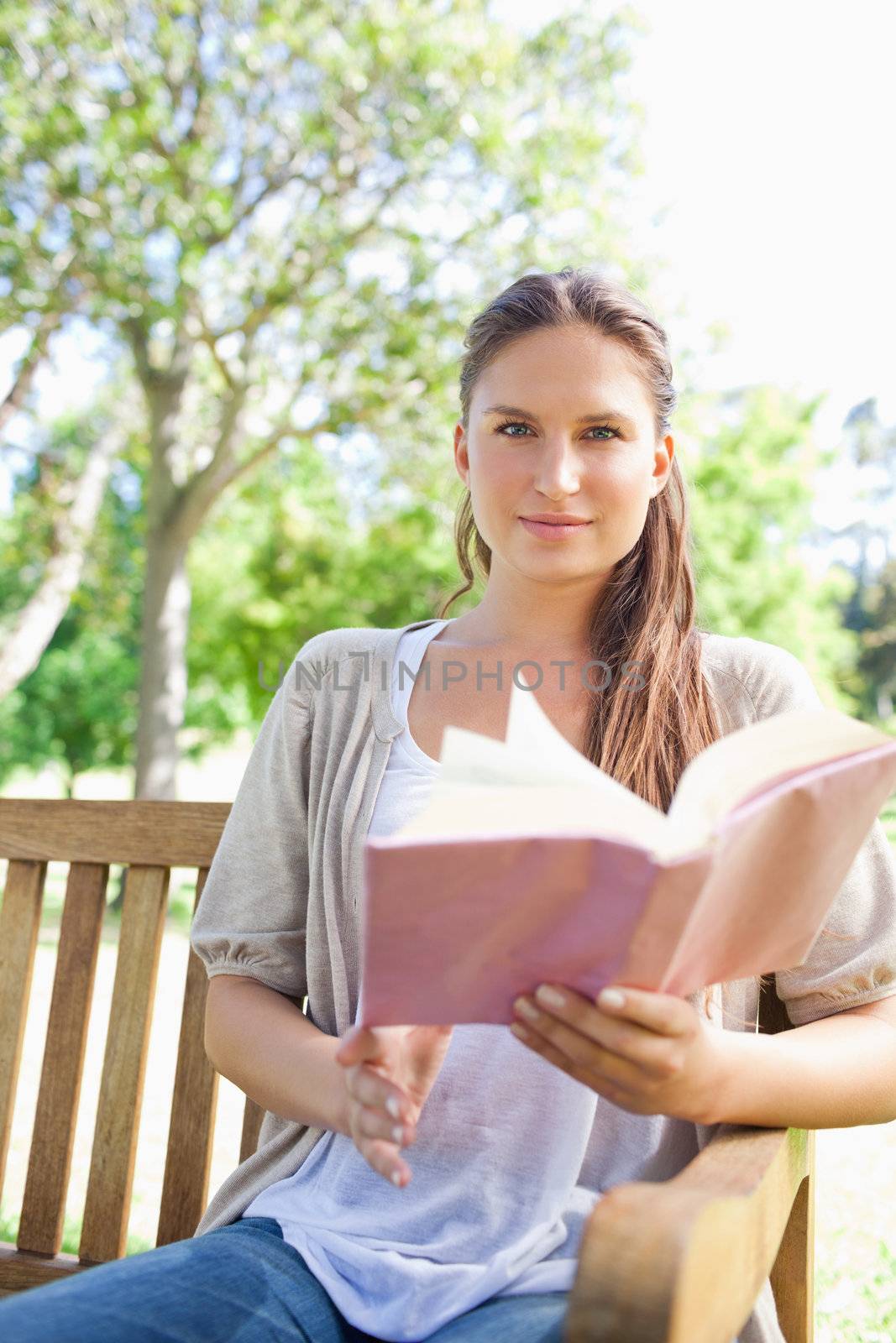 Woman sitting on a park bench with her book by Wavebreakmedia