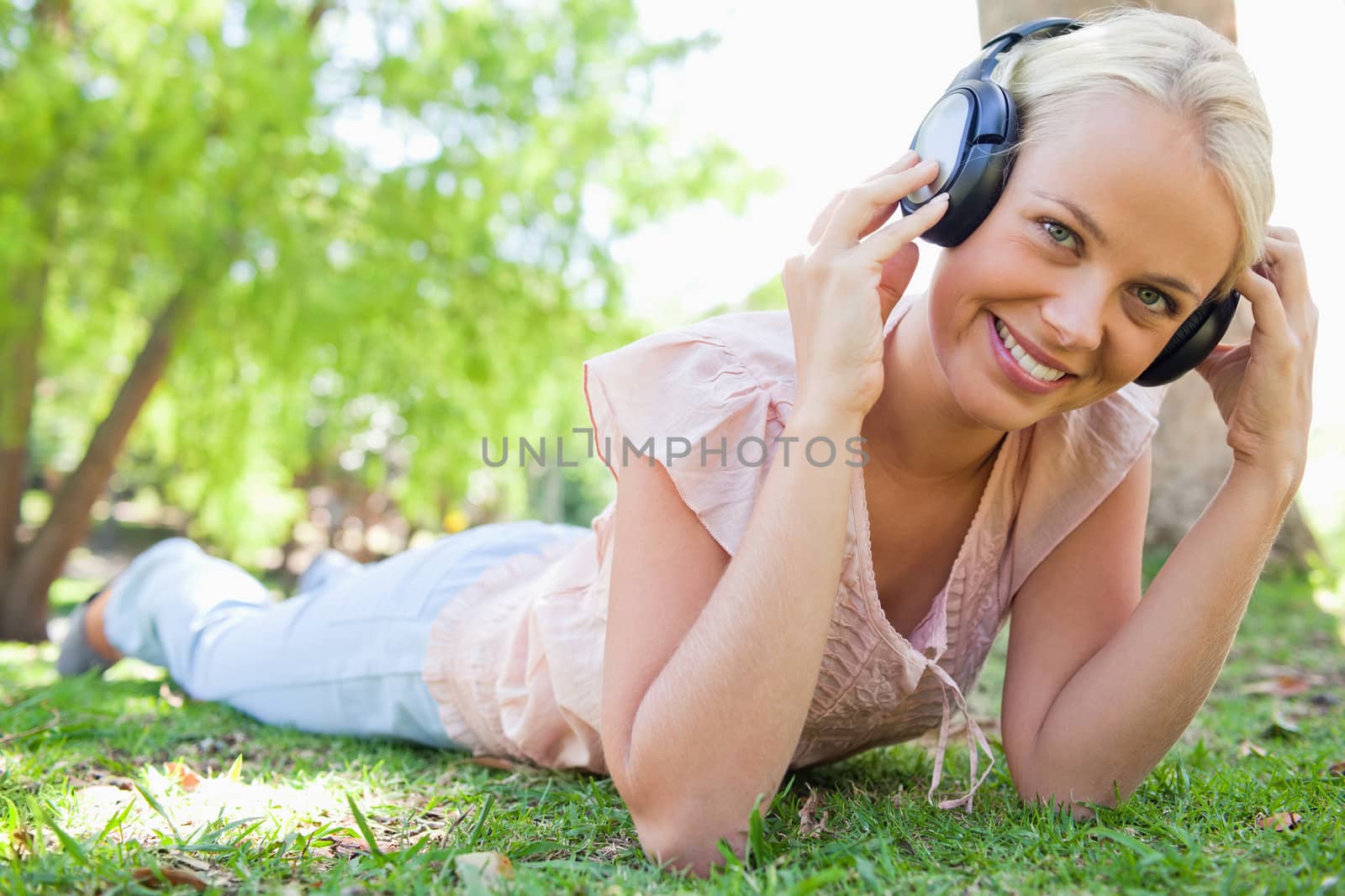 Smiling woman enjoying music on the grass by Wavebreakmedia