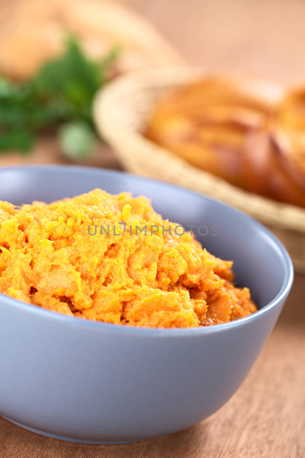 Bowl of sweet potato spread with sweet potato buns in bread basket in the back (Selective Focus, Focus one third into the spread)